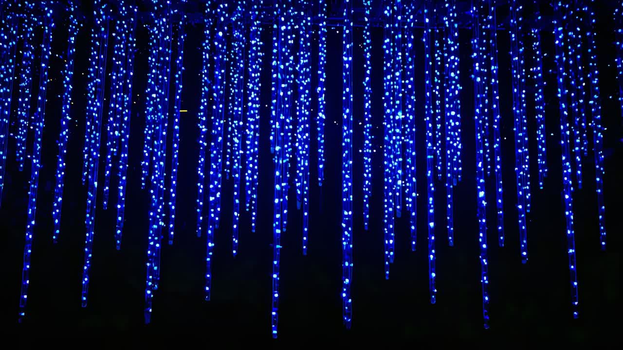 Pulsing blue LED strands shifting at dark venue ceiling with rail, lighting system sending pulses
