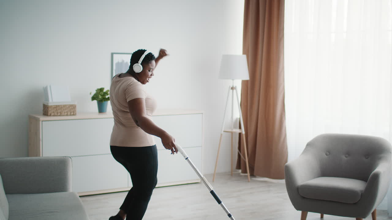 Happy Woman Dancing While Vacuuming