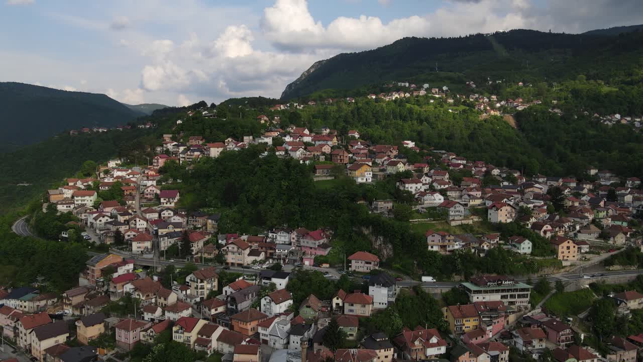 casas construidas sobre y alrededor de colinas verdes, vista de árboles entre edificios