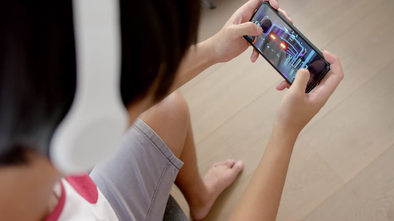 un adolescente asiático juega un juego móvil en casa, con espacio para copiar