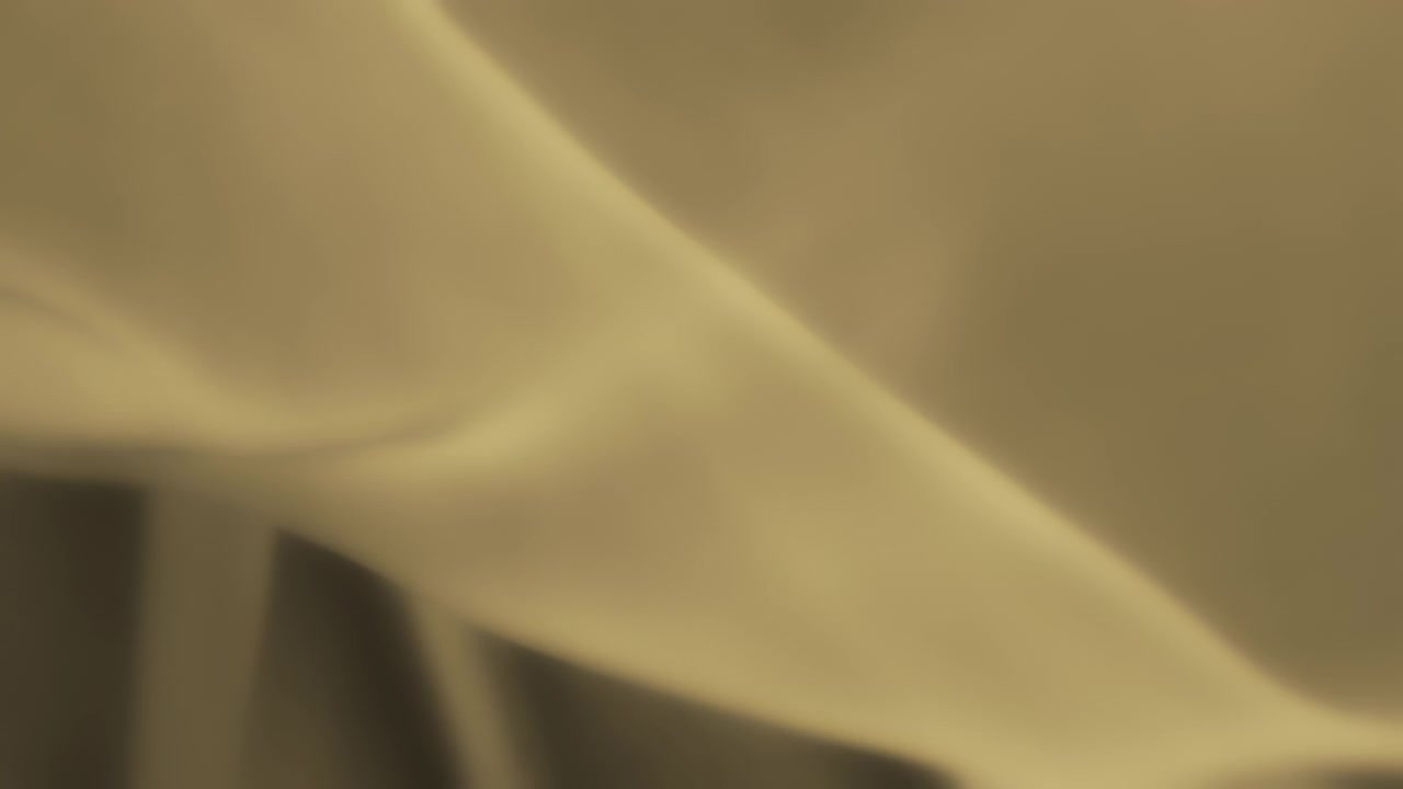 Abstract background of yellow chiffon textile waving in the wind