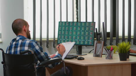 disabled businessman taking notes in business office