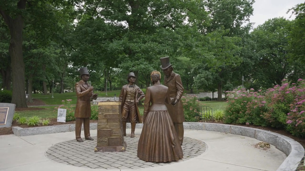 Filmisk indzoomning fra skiltet ved Pennsylvania State Capitol mod monumentet "A Gathering at the Crossroads For Such a Time as This" i Harrisburg, Pennsylvania.