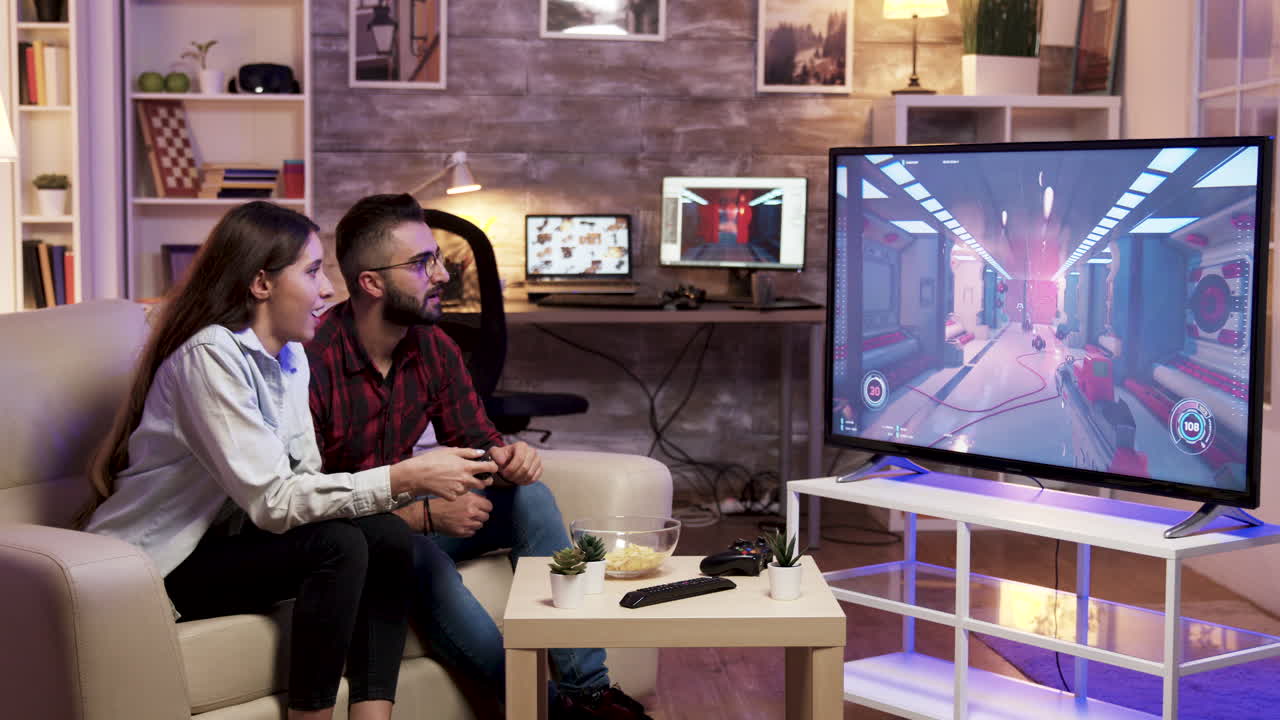 Couple playing video game together at home