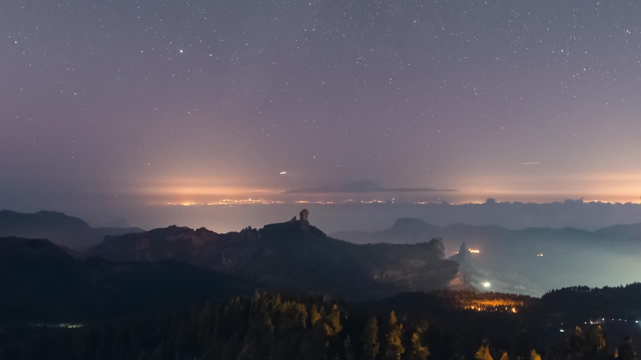 Breathtaking timelapse of Roque Nublo at night, nightlight scene over the mountains and Teide in the distance. A serene and cinematic scene, perfect for nature, travel, and adventure projects.