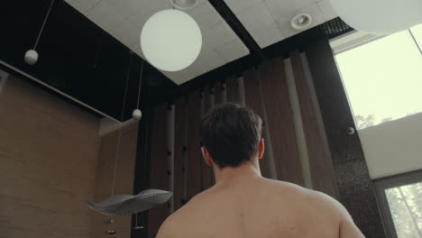vista de abajo hombre guapo va bar spa interior. tipo atlético hablando camarero