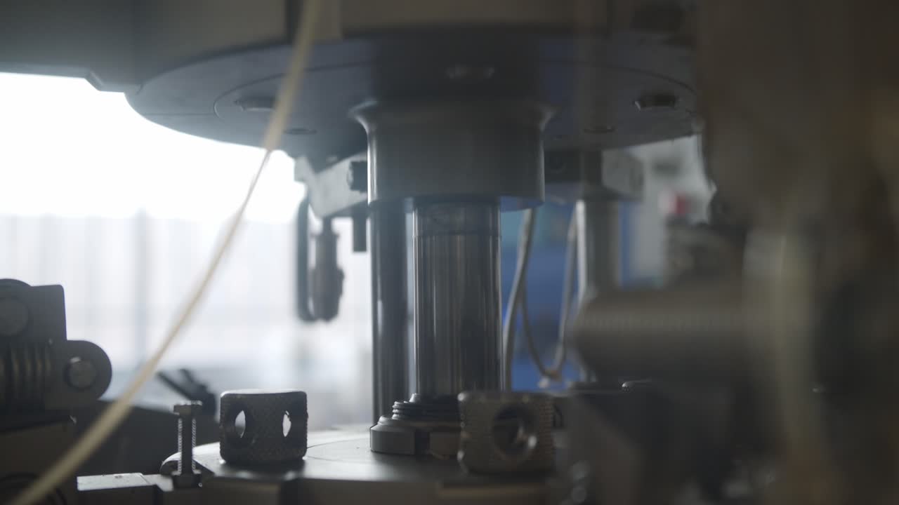 maquinaria automatizada bombeando hacia arriba y hacia abajo en una industria de fabricación de cosméticos - cámara lenta