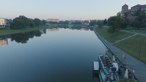 Toma-Aérea-De-Drones-Del-Casco-Antiguo-Del-Castillo-De-Wawel-En-Cracovia,-Polonia,-Con-El-Río-Vístula-Al-Amanecer.