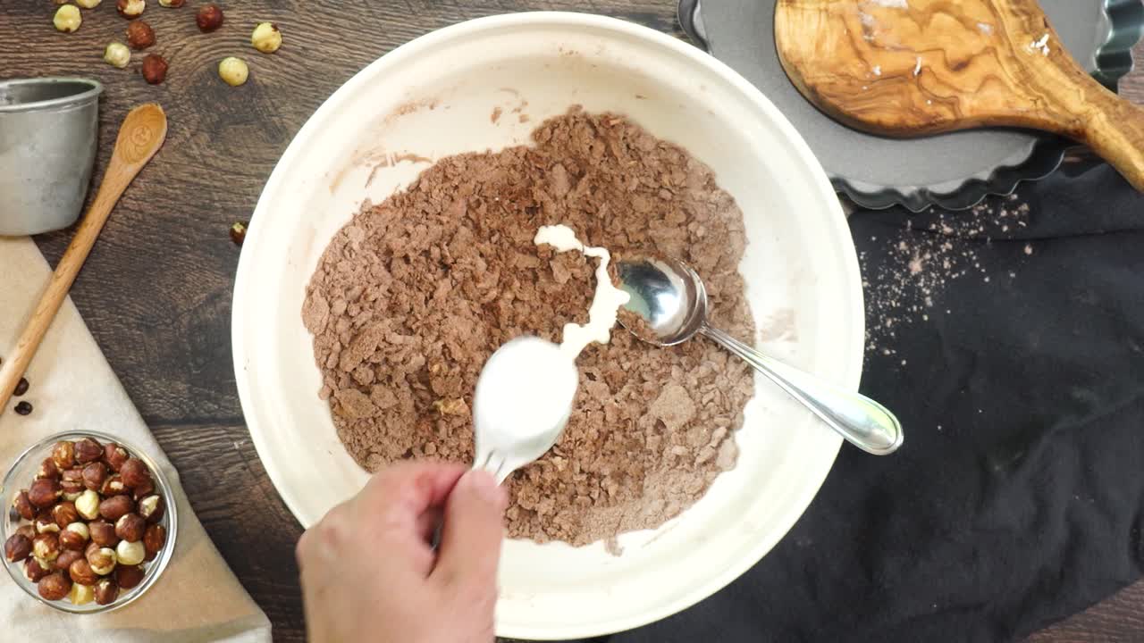 A delicious dessert, Coffee Hazelnut Cream Tart. Made with espresso powder, chocolate crust and loaded with crushed hazelnut. Adding milk o cream to the mixing bowl to make the chocolate pie crust