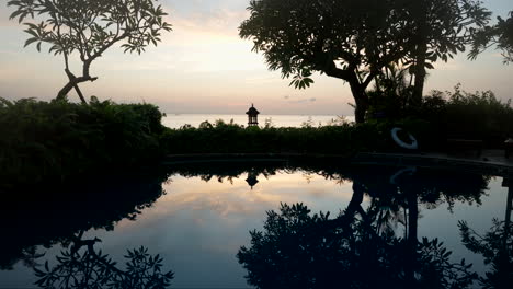 Silhouettes-Reflected-On-The-Swimming-Pool-On-The-Luxury-Hotel-Resort-In-Amed,-Bali-Indonesia