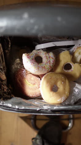 vertical pov of dumping leftover junkfood and candies into bin