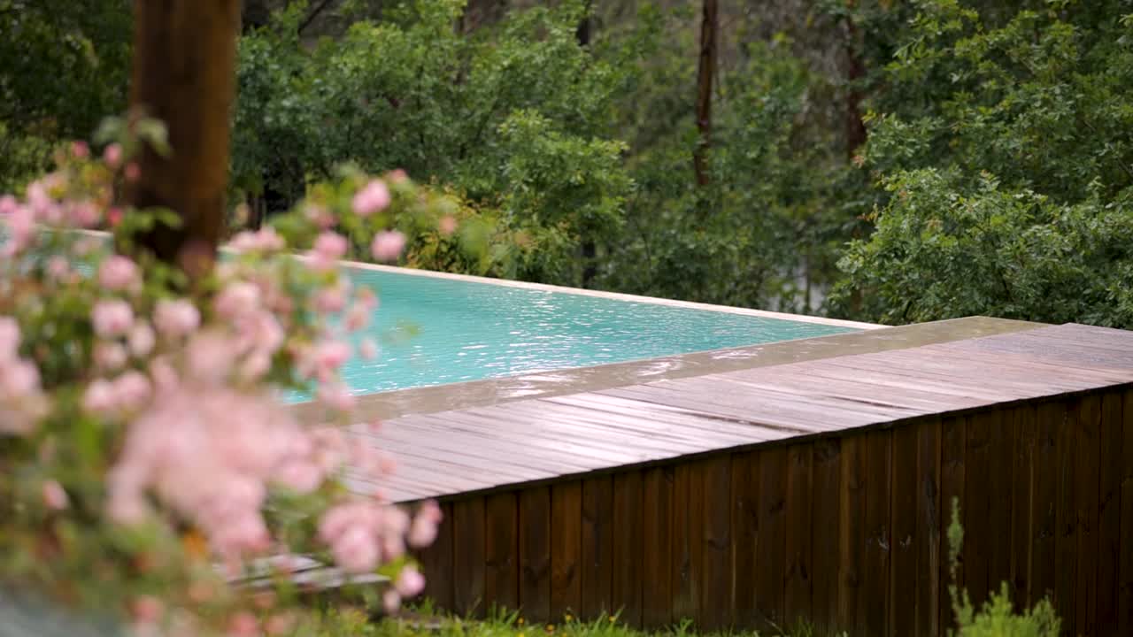 Luxury Poolside with Pink Flowers on a Breezy Summer Day