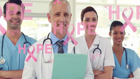 Animación-De-Texto-De-Esperanza-Con-Logotipos-De-Cinta-Rosa,-Flotando-Sobre-Médicos-Y-Doctoras-Sonrientes