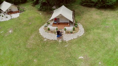vista aérea de una pareja de pie frente a una zona de descanso en un campamento.