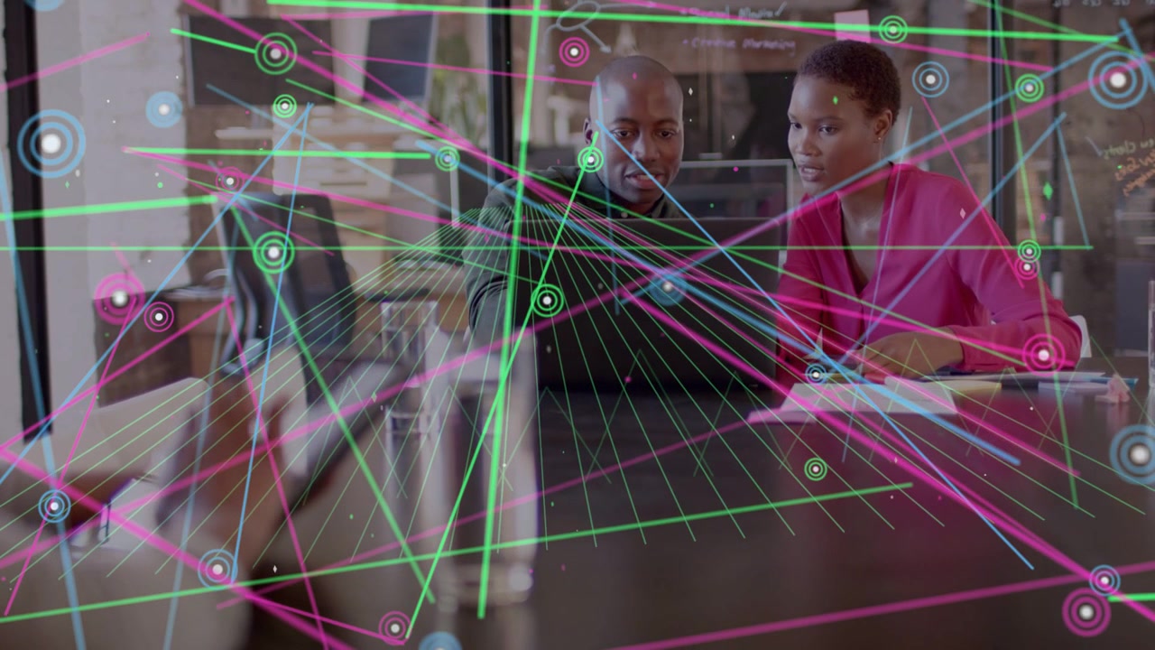 Man tapping laptop, woman noting, animated nodes overlaying table and notes, aiding biz decisions