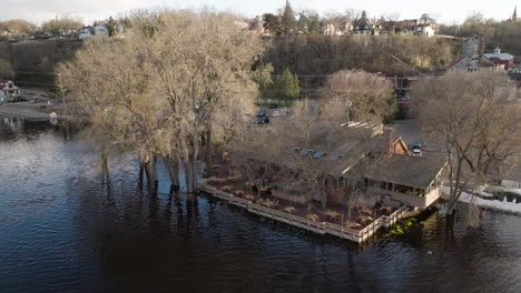 severe flooding from overflowing river damages marina, roads and buildings during natural climate disaster