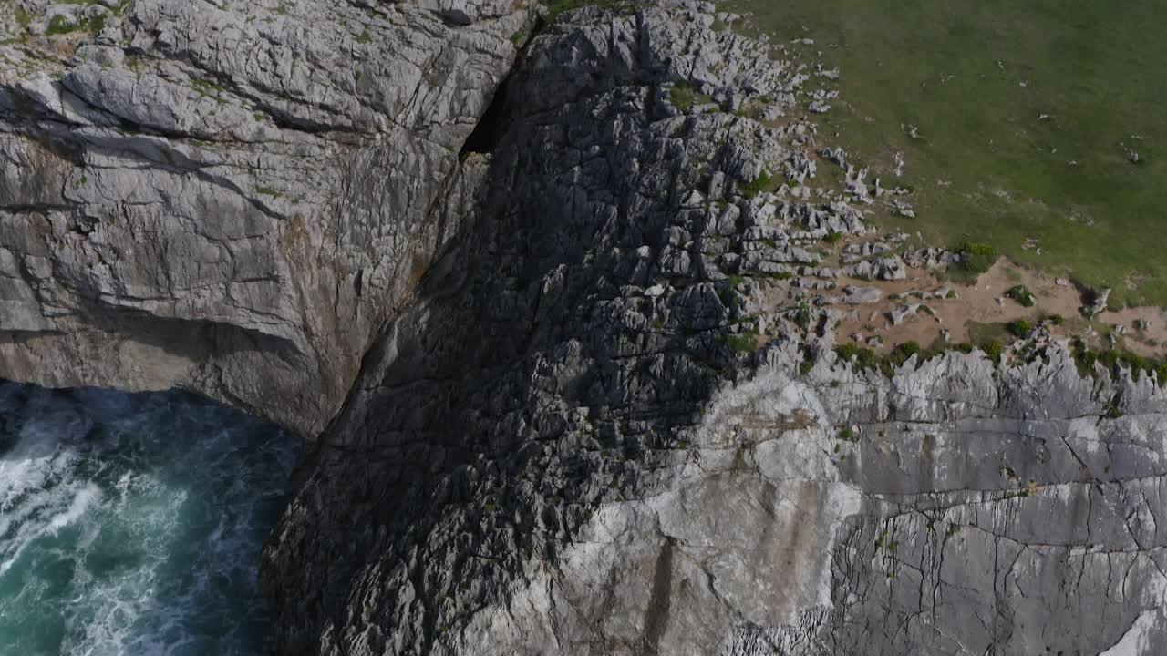 Jagged eroded limestone cliffs to grassy green hills of bufones de pria asturias spain, aerial tilt up