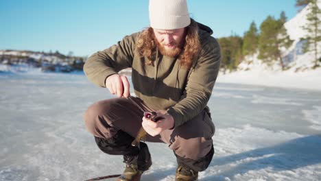 El-Hombre-Está-Preparando-El-Pescado-Que-Pescó-Mientras-Pescaba-En-El-Hielo-En-Bessaker,-Condado-De-Trondelag,-Noruega---Primer-Plano