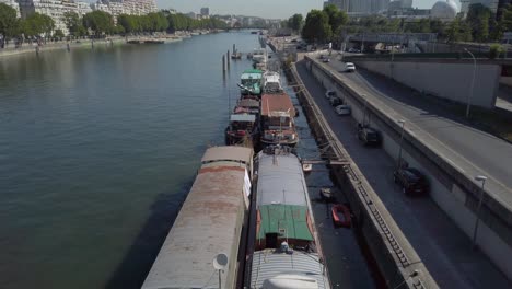 Toma-Aérea-De-Drones-De-Barcos-Atracados-A-Lo-Largo-De-La-Orilla-Del-Río-Sena-En-París