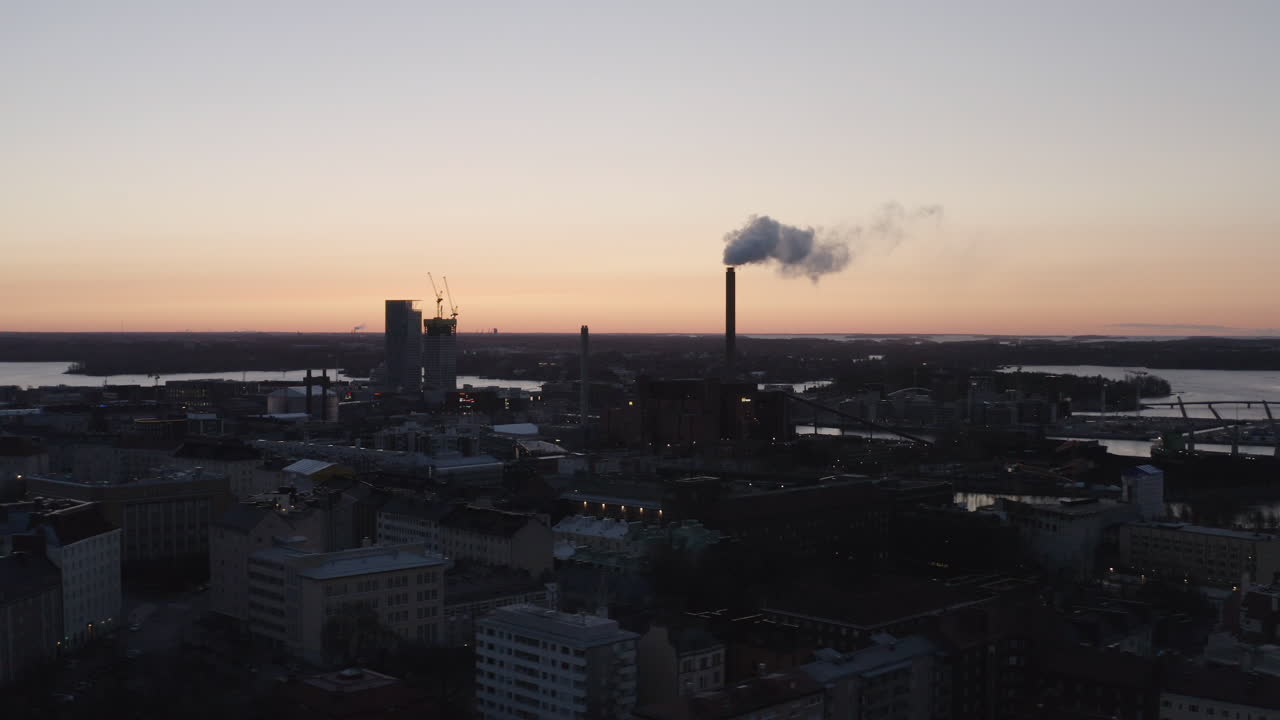 Aerial drone view of city and industrial chimney exhaust smoke and steam. Air Pollution