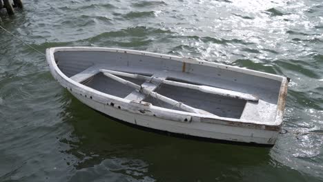 pequeño barco blanco vacío de madera de un viejo pescador flotando en el mar