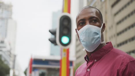 Animation-of-virus-cells-over-african-american-man-wearing-face-mask