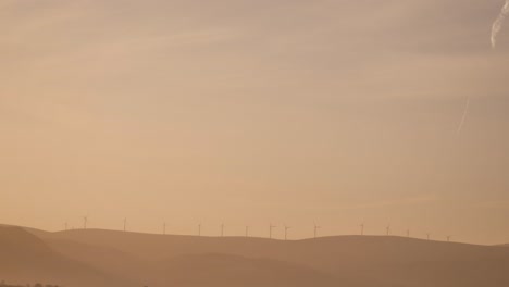 golden sunrise over wind turbines in a rural area of scotland in winter in perth shire, united kingdom