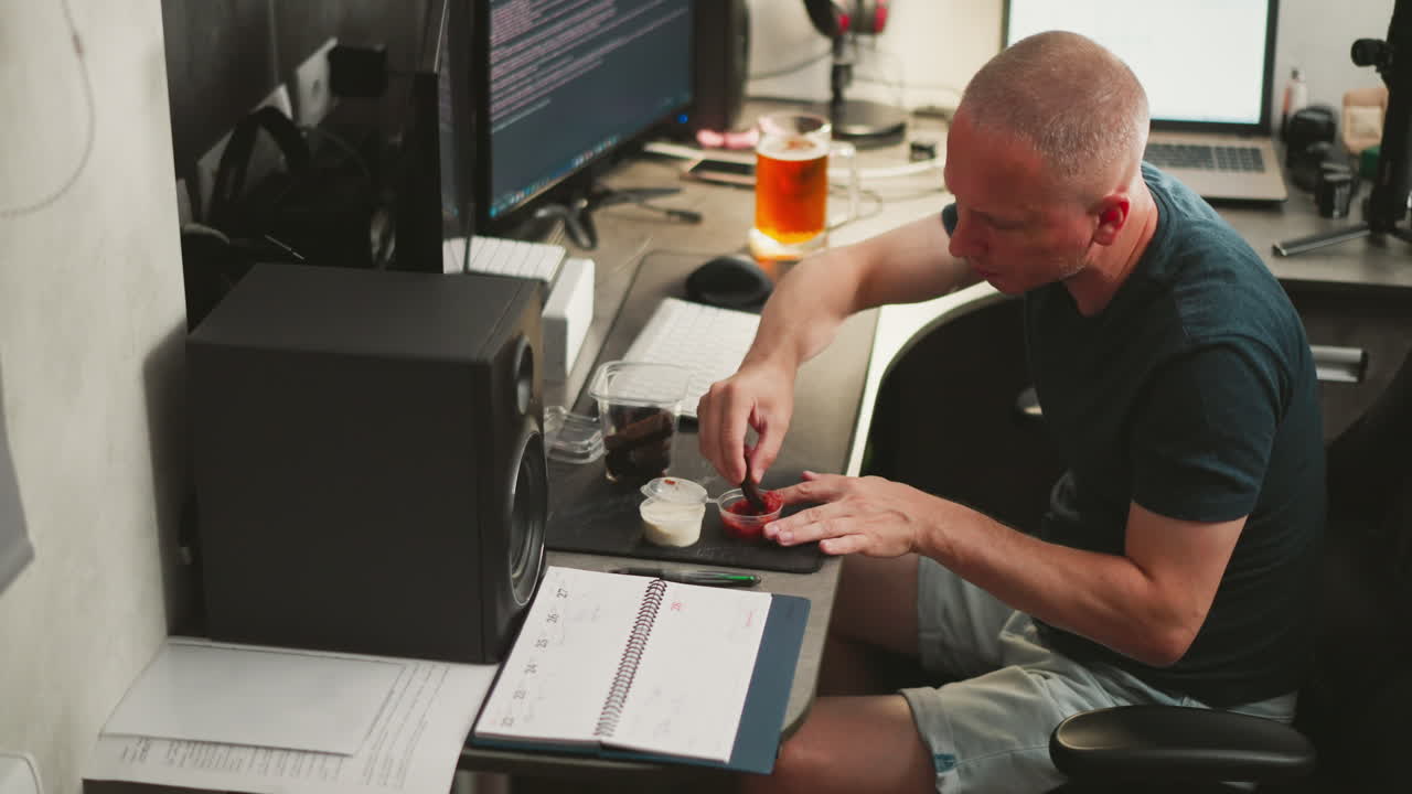 Man eating snack at home office desk