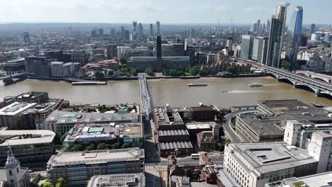 aerial flyover of st. paul’s cathedral in london, gliding towards millennium bridge and the river thames. stunning cityscape with iconic architecture and historic landmarks in cinematic view