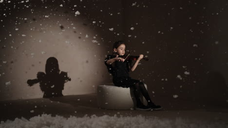 young girl playing violin in a snowy studio