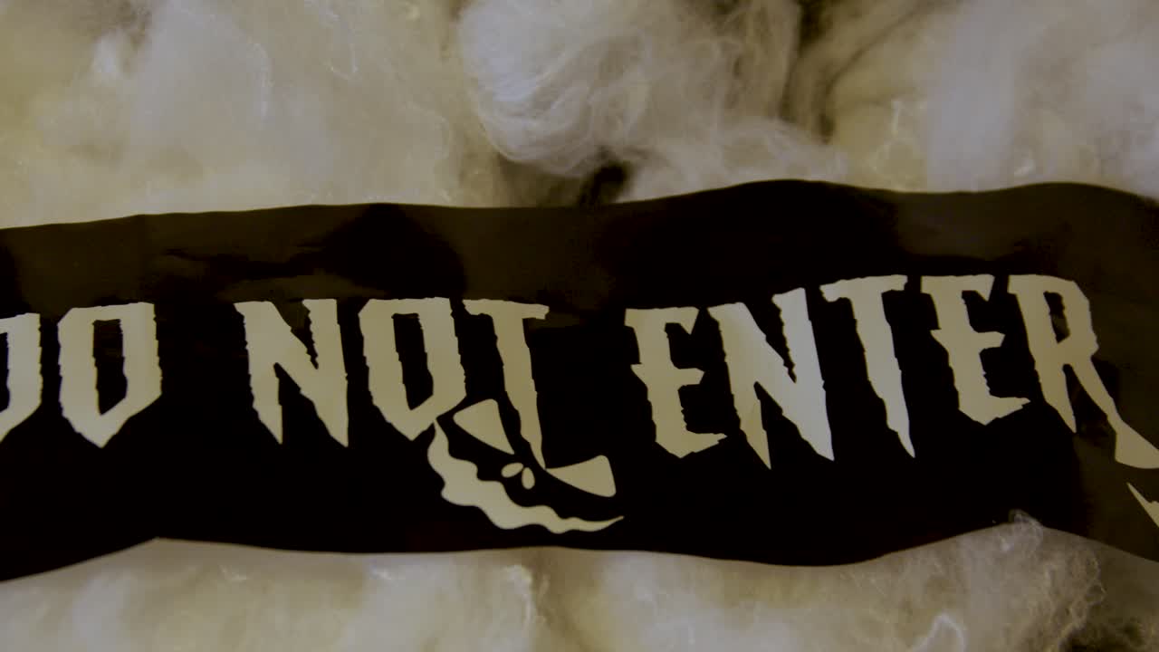 Pan across &amp;quot;Do Not Enter&amp;quot; Halloween banner on decoration spider web