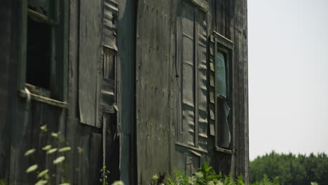 Wind blows quickly, broken open window and cloth curtain of ramshackle wooden building