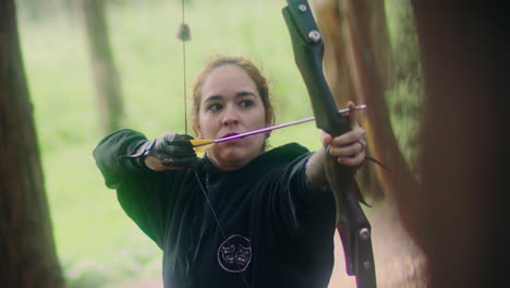 archery woman pulls and shoots arrow super slow motion front shot