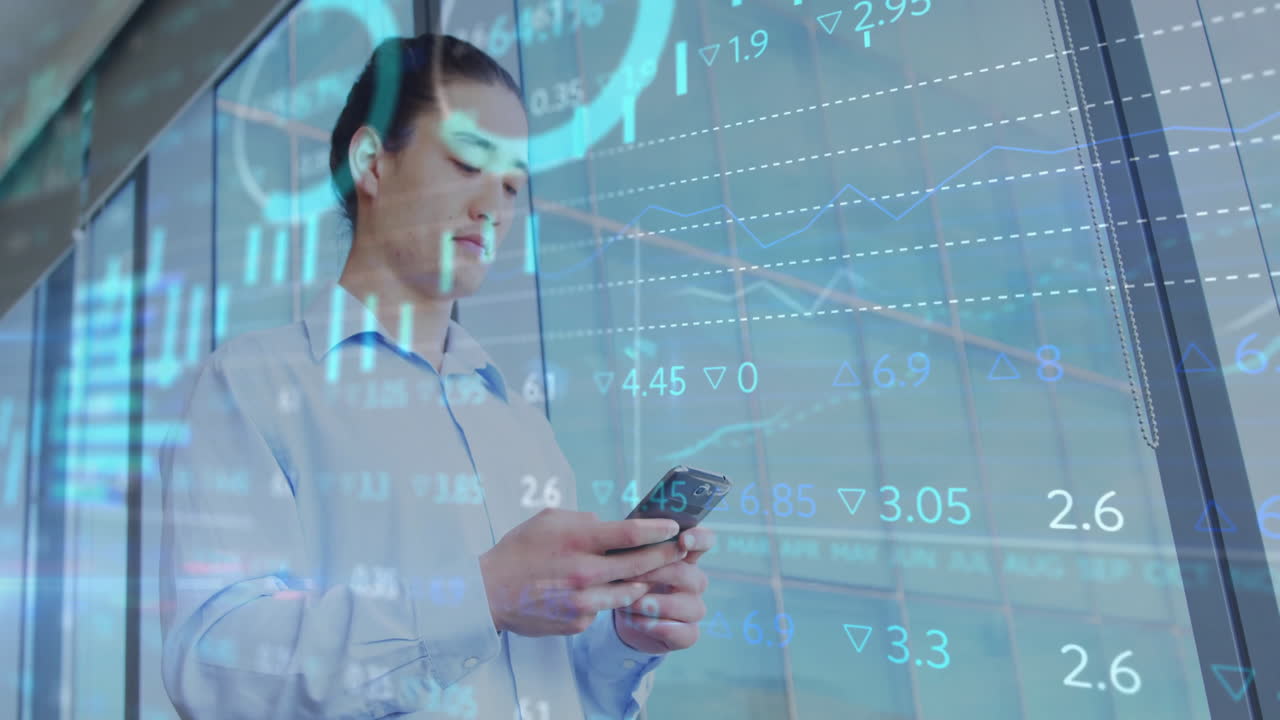 Professionista aziendale in piedi nel corridoio dell'ufficio che usa uno smartphone con dati aumentati del mercato azionario