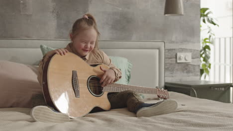 caucasian girl with down syndrome playing the guitar