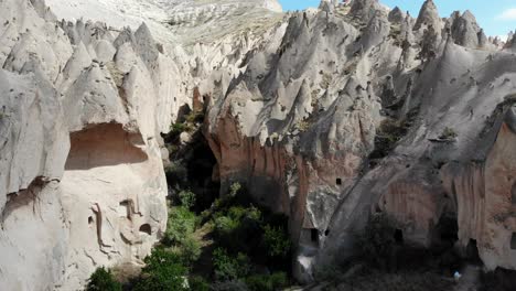 Starting-inside-the-Zelve-ancient-village-a-drone-move-up-and-backward-slowly-revealing-the-entire-village-landscape---Kapadokya