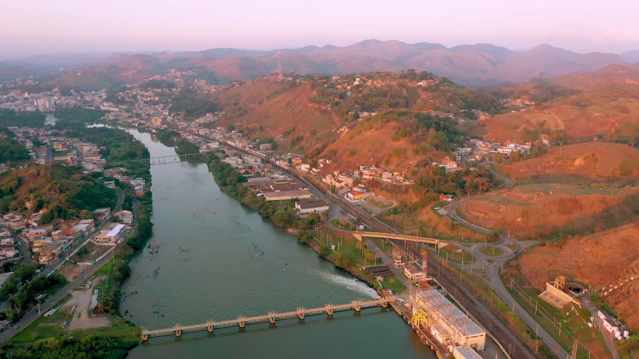 Aerial view of a city, river, and infrastructure at dusk
