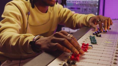 african american man working at mixing desk in recording studio