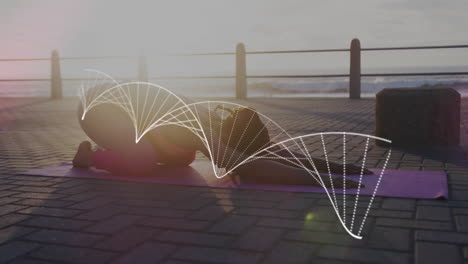 estructura de adn contra afroamericana mujer en forma realizando yoga en el paseo marítimo