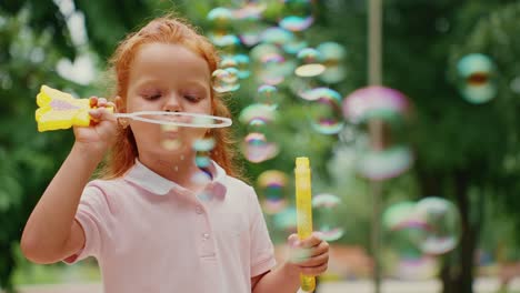 little girl blowing bubbles in a park