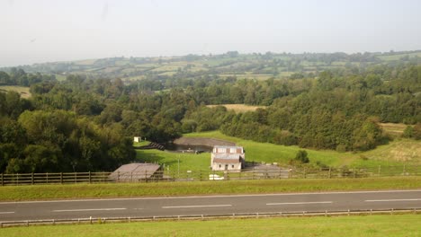 Wide-shot-of-Carsington-Water-treatment-works-with-the-dam-road-foreground-with-cars-passing-through-frame