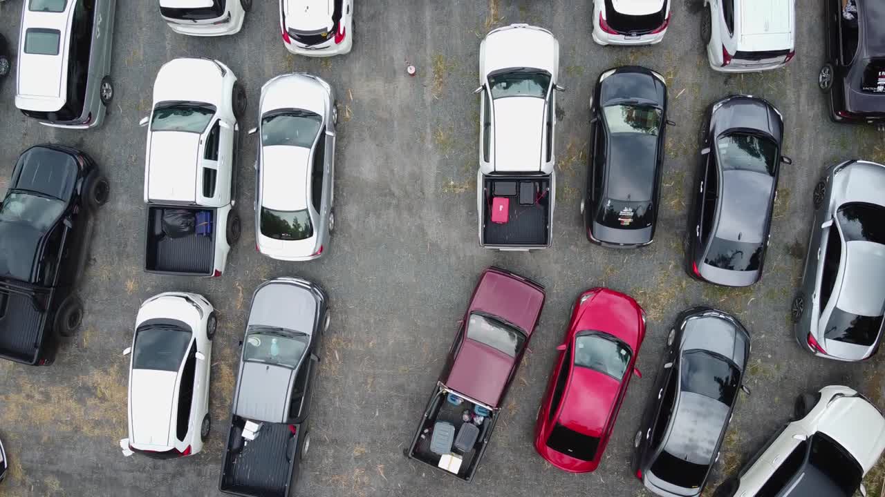 공중:10열의 차가 있는 포장된 주차 구역의 하향식 드론 보기, 대기열에 갇힌 사람들은 코 창 섬에서 트랏 본토, 태국, 아시아로 가는 페리를 기다립니다.