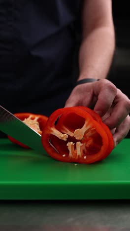 chef cutting a red bell pepper