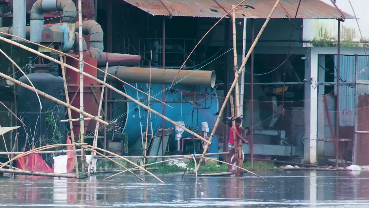 Net fishing polluted river Bangladesh near industrial factory plant Southeast Asia