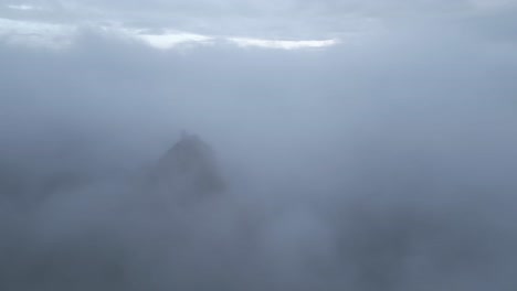 ruins on mountain peak above clouds on foggy day