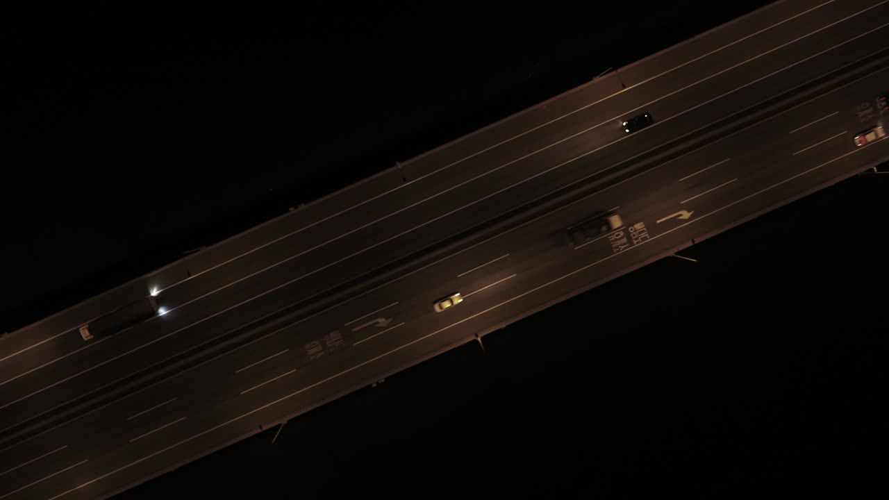 Cars passing through four-lane roads in the middle of the night, top view drone shot