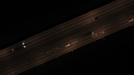 Cars passing through four-lane roads in the middle of the night, top view drone shot