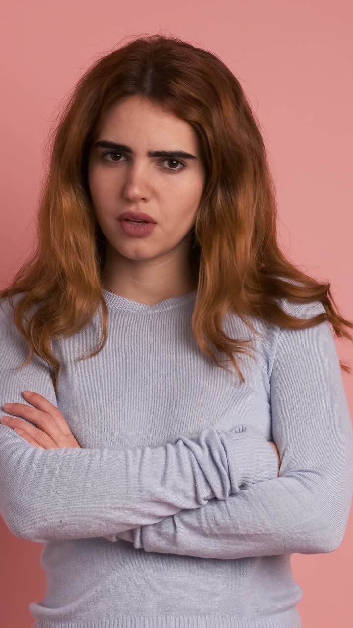 Young woman crossing arms while gesturing negation with head. Vertical Footage