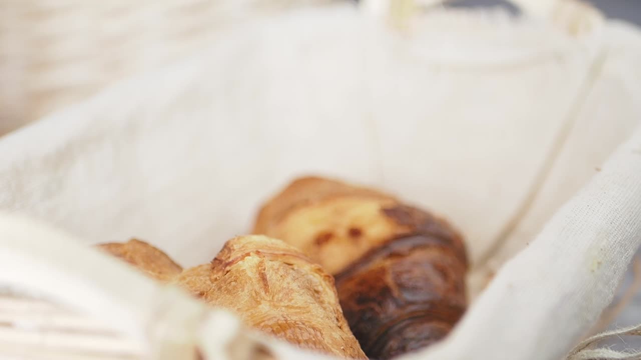 Hand Picking Up Fresh Baked Bread from a Basket