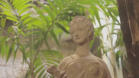 sculpture of an ancient goddess or nymph on a green patio garden